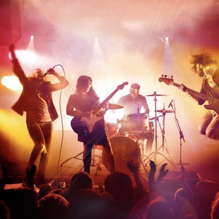 Band performing under bright stage lights, reflecting learning challenges that build momentum